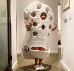 a woman dressed as a giant white object with holes in it's body and hands