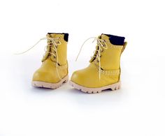 a pair of yellow boots sitting on top of a white floor