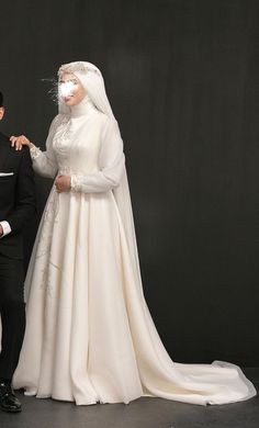 a man in a tuxedo standing next to a woman in a wedding dress