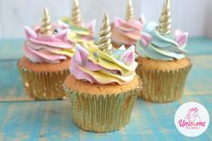 cupcakes decorated with colorful icing and unicorn hats