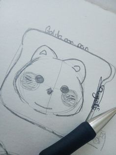 a drawing of a bear on paper with a pen