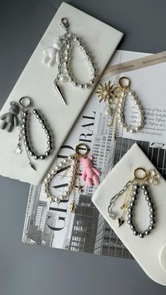 four pairs of keychains with pearls and bows on them sitting next to each other