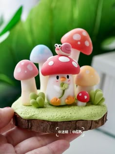 a hand holding a small toy with mushrooms on it