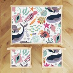 three wooden boxes with sea animals and fish on them, sitting on a wood floor