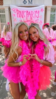 two girls dressed in pink posing for the camera