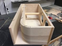 a wooden boat sitting on top of a table next to other woodworking tools and equipment