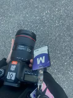 a person holding up a camera with the lens attached to their thumb and flash card