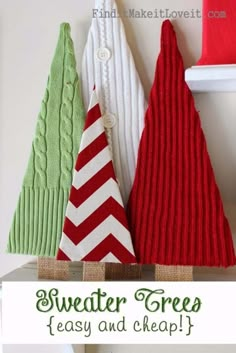 three knitted christmas trees sitting next to each other on top of a shelf in front of a white wall