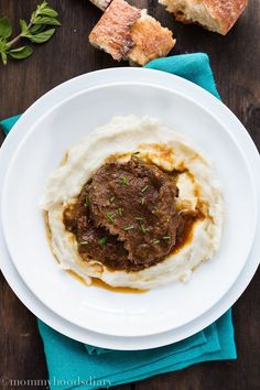 a white plate topped with mashed potatoes and meat