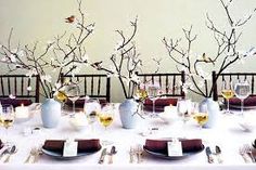 there are several vases with branches in them on the table and one is empty