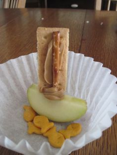 a hot dog on a bun with mustard and apple slices