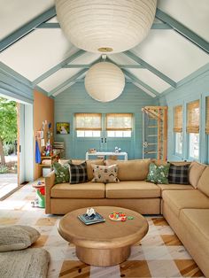 a living room filled with furniture and a skylight hanging over the top of it