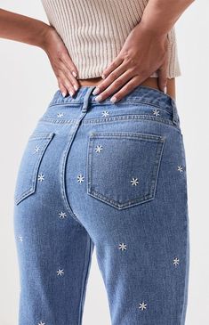 a woman with her back to the camera, wearing jeans that have stars on them