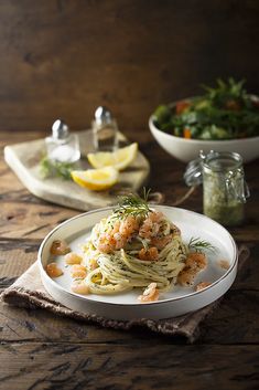 a white plate topped with pasta and shrimp