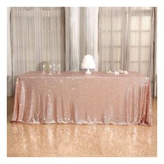 the table is covered with pink sequins and has a white cake on it