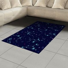 a blue area rug with stars on it in front of a white couch and pillows