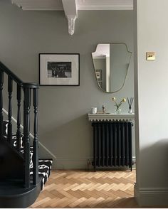 a room with a mirror, radiator and pictures on the wall in it