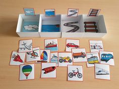 there are many cards in the box on the table and one has an airplane, hot air balloon, train, car, plane