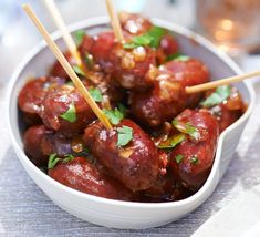 a white bowl filled with meatballs and chopsticks