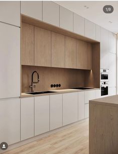 an image of a kitchen setting with white cabinets and wood flooring on the walls