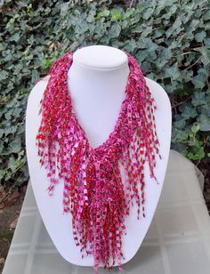 a white mannequin with pink and red beads on it's neckline