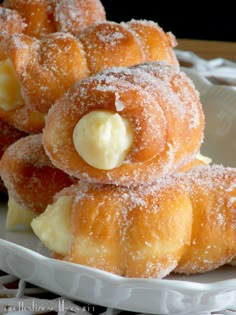 powdered sugar covered doughnuts on a white plate with butter in the middle