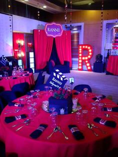 a red and blue party with pink drapes, black tablecloths and neon lights