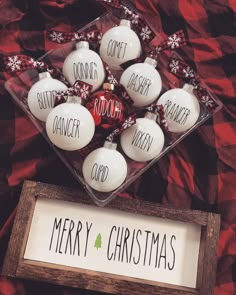 christmas baubles are displayed in a box on a bed with red and white sheets