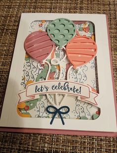 a card with some balloons on it and the words let's celebrate written in blue