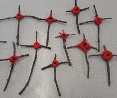 several pieces of red plastic sitting on top of sticks with holes in the middle that have been cut out to look like branches