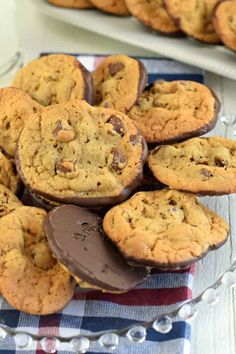 a plate full of cookies and apples on a wooden table with pecans around it