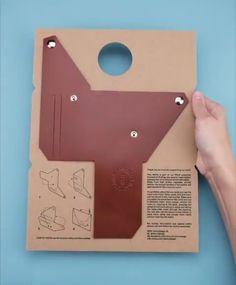 a person holding a piece of cardboard with holes in it