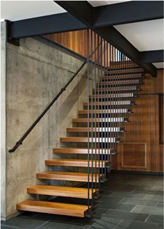 a set of stairs with wooden treads next to a wall