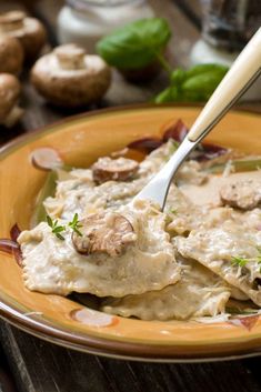 a yellow plate topped with ravioli and mushrooms