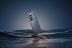 a silver cell phone floating on top of water