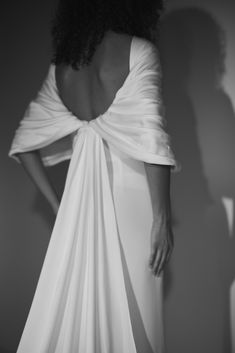 the back of a woman's dress with her hands on her hips, in black and white