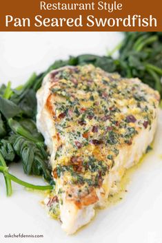 a white plate topped with green vegetables and fish