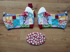 two pieces of fabric sitting on top of a wooden floor next to a patchwork piece