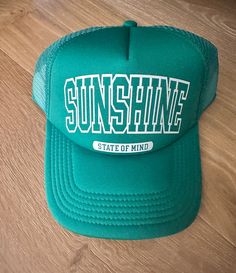 Embrace that laid-back, sunny vibe with this 'Sunshine State of Mind' Trucker Hat. This trendy piece is not just an accessory, but a statement of your love for open roads and clear skies. This green trucker hat features an adjustable snapback for maximum comfort and a perfect fit.   It's the perfect hat to remind you of sunny days and good vibes no matter where you are or what the weather is.  Flash this hat for your next trip or outdoor adventure! tag us @rowdiethreads Sunshine State of Mind | Trucker hat | Summer Hat | Summer Trucker Hat | Summer Trucker hat Summer Trucker Hat, Green Trucker Hat, Sunshine State Of Mind, Open Roads, Green Cap, Hat Summer, Clear Sky, Summer Hat, Sunshine State