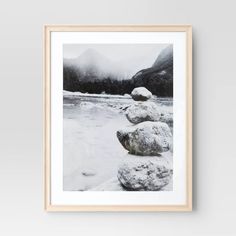 a black and white photo of rocks in the snow