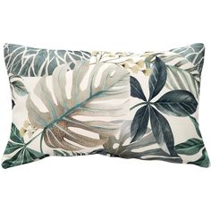 a white and green pillow with tropical leaves on the front, along with gold accents