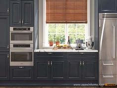 an image of a kitchen setting with gray cabinets and stainless steel appliance set