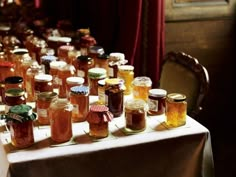 a table topped with lots of jars filled with liquid