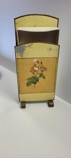 an old fashioned wooden box with flowers painted on it's front and side panels