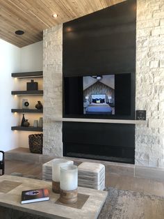 a living room with a large flat screen tv mounted on the wall next to a fireplace