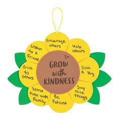 a flower shaped ornament with the words grow with kindness written in different languages