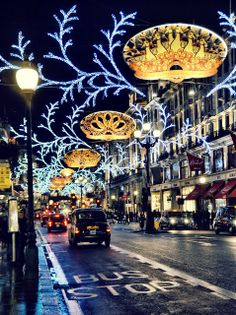 cars driving down a street with christmas lights on it