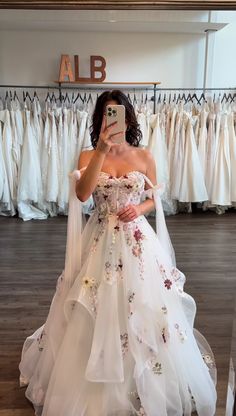 a woman is taking a selfie in her wedding dress at the bridal shop