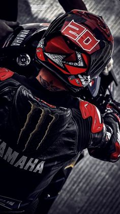 a man wearing a red and green helmet on top of a motorcycle