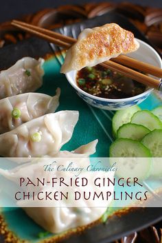 a plate with dumplings, cucumbers and dipping sauce on it that says pan fried ginger chicken dumplings